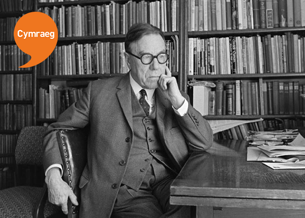 Black and White photo of T H Parry-Willimas siting in his study at a desk with Welsh Language Speachmark Logo